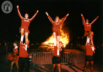 cheerleaders in front of a bonfire